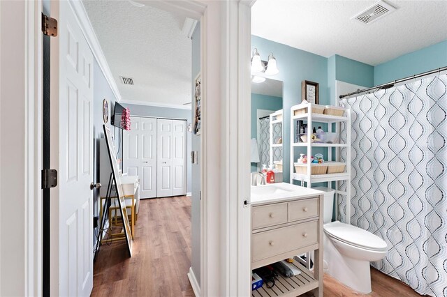 bathroom with a textured ceiling, vanity, and hardwood / wood-style floors