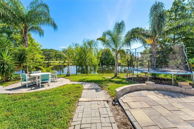 exterior space featuring a patio area, a water view, and a trampoline