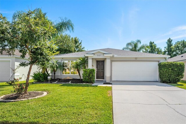 single story home featuring a garage and a front yard