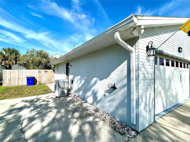 view of home's exterior featuring a garage and central AC