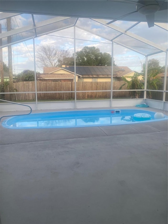 view of pool featuring glass enclosure