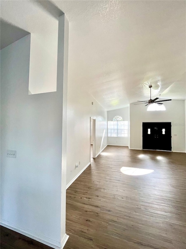 unfurnished living room with vaulted ceiling, ceiling fan, and dark hardwood / wood-style floors