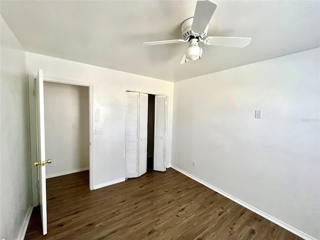 unfurnished bedroom featuring ceiling fan, a closet, and dark wood-type flooring