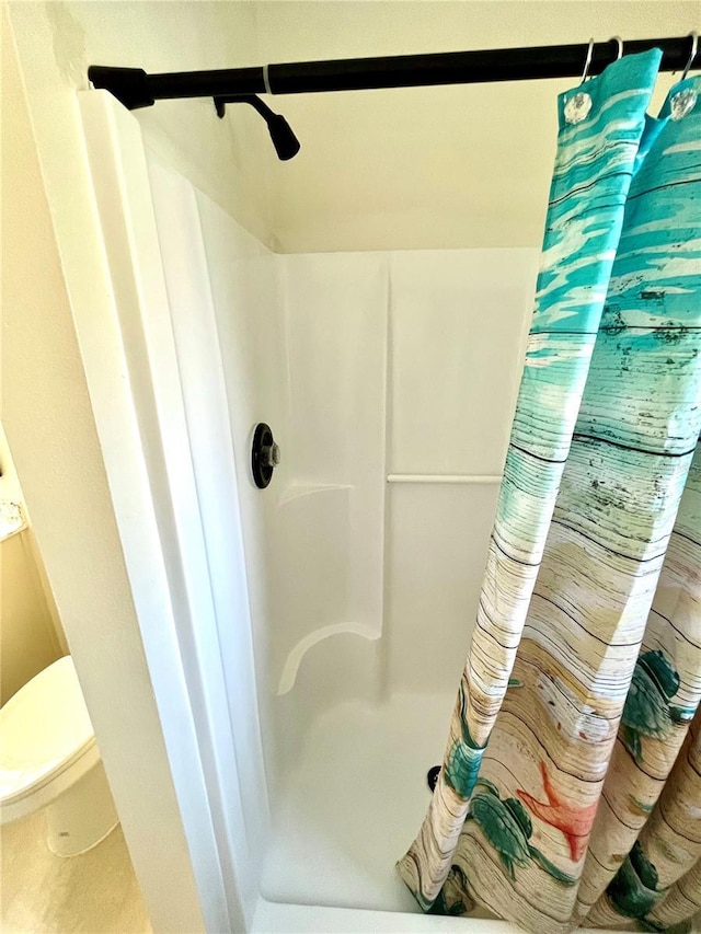 bathroom with curtained shower and toilet