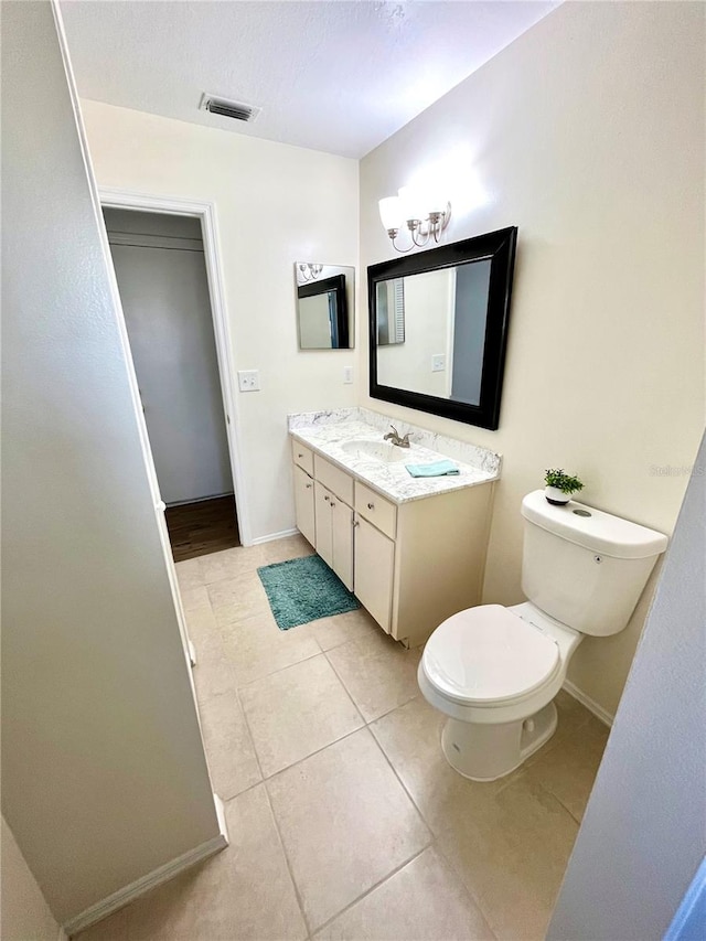 bathroom featuring tile patterned flooring, vanity, and toilet