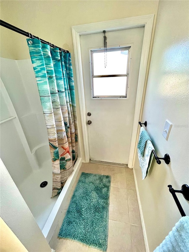 bathroom with tile patterned flooring and walk in shower