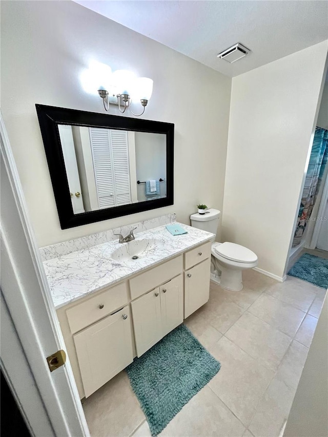 bathroom featuring tile patterned flooring, vanity, and toilet