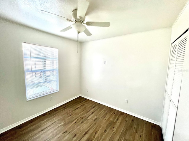 unfurnished bedroom with a closet, ceiling fan, and dark wood-type flooring