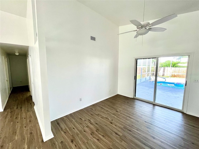 empty room featuring ceiling fan, high vaulted ceiling, and dark wood-type flooring