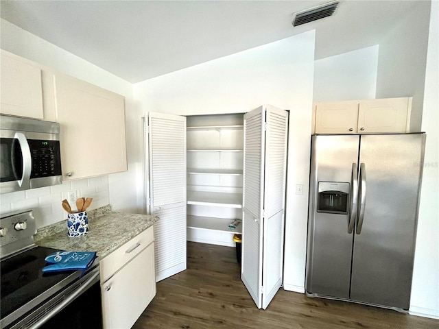 kitchen with backsplash, dark hardwood / wood-style flooring, white cabinets, and stainless steel appliances