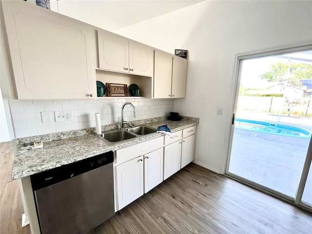 kitchen featuring white cabinetry, sink, dishwasher, light stone counters, and hardwood / wood-style flooring