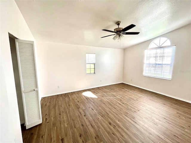 spare room with a textured ceiling, dark hardwood / wood-style flooring, and ceiling fan