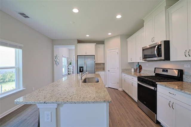 kitchen featuring sink, an island with sink, white cabinets, and appliances with stainless steel finishes