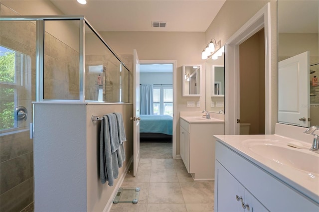 bathroom featuring vanity, toilet, a shower with door, and tile patterned flooring