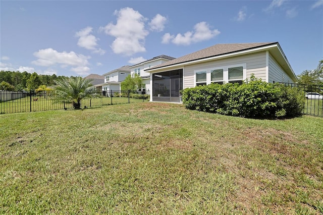 back of property with a sunroom and a lawn