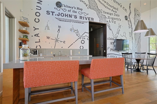 bar featuring sink and light hardwood / wood-style flooring