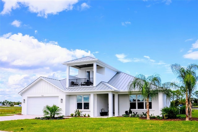 view of front of property with a balcony, a front yard, and a garage