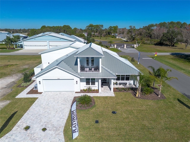 view of front of home with a balcony, a garage, and a front lawn