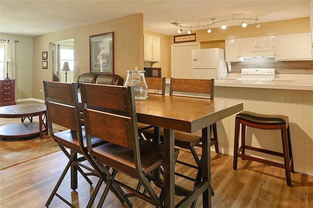 dining area featuring baseboards and light wood-style floors