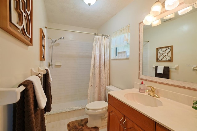 full bath with a textured ceiling, vanity, a tile shower, and toilet