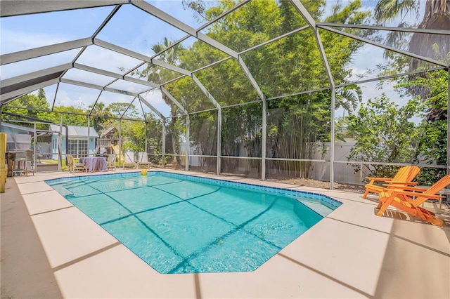 view of pool with glass enclosure and a patio