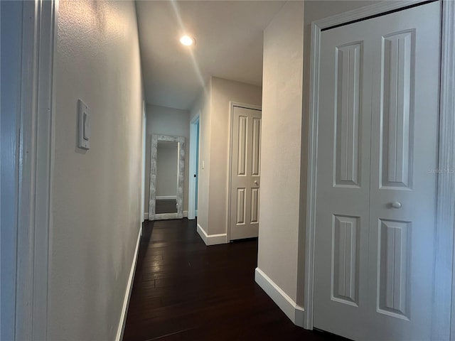 hallway featuring recessed lighting, baseboards, and dark wood-style floors