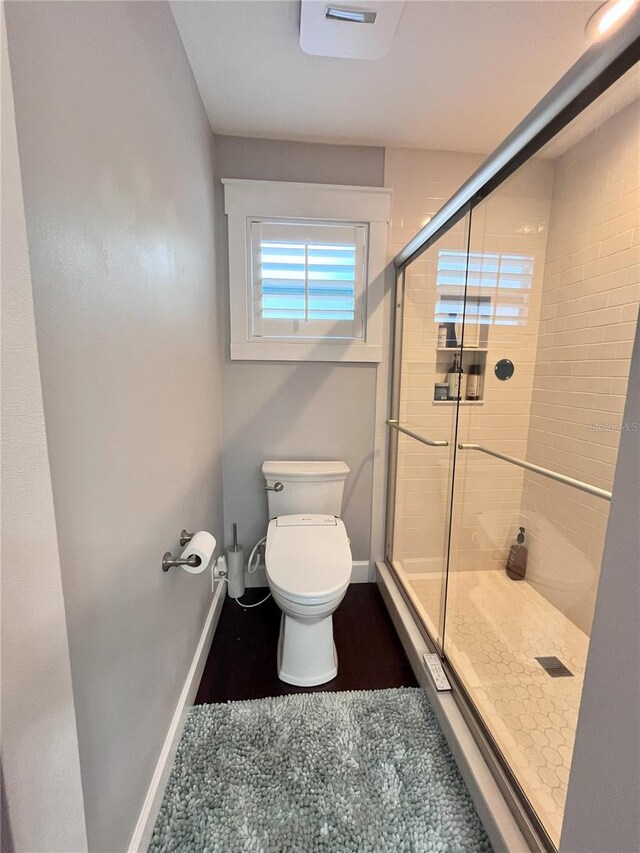 bathroom featuring an enclosed shower and toilet