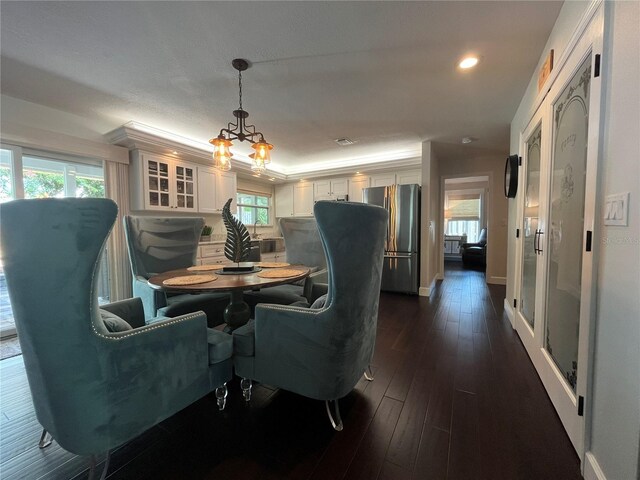 dining area featuring dark hardwood / wood-style flooring, an inviting chandelier, and a wealth of natural light