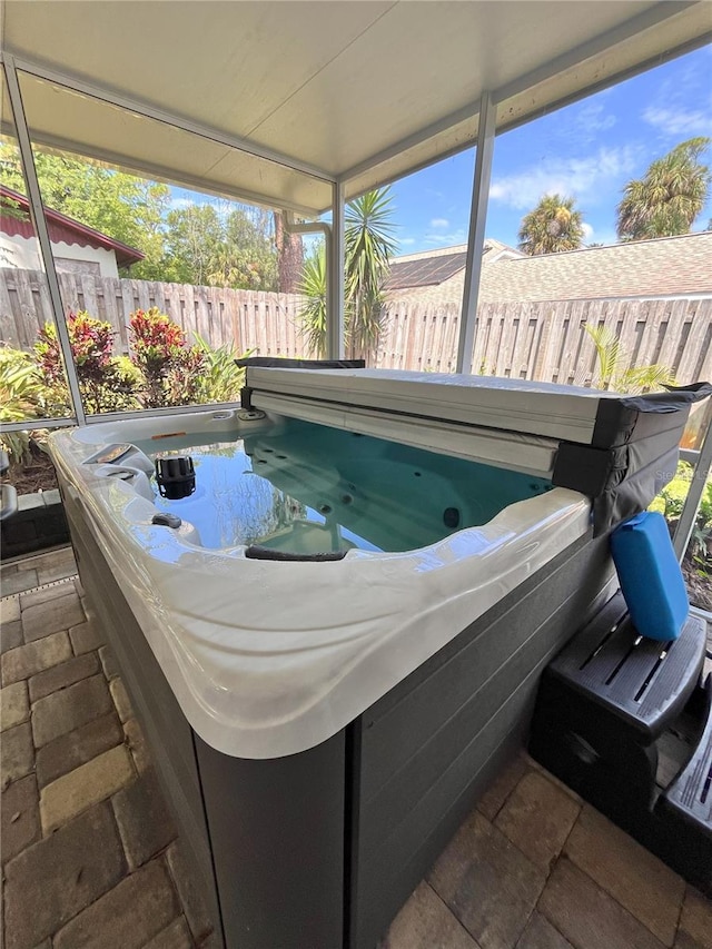 exterior space featuring a wealth of natural light and a hot tub