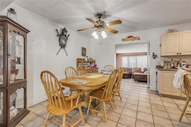 dining space with light tile patterned floors, a ceiling fan, and a textured ceiling