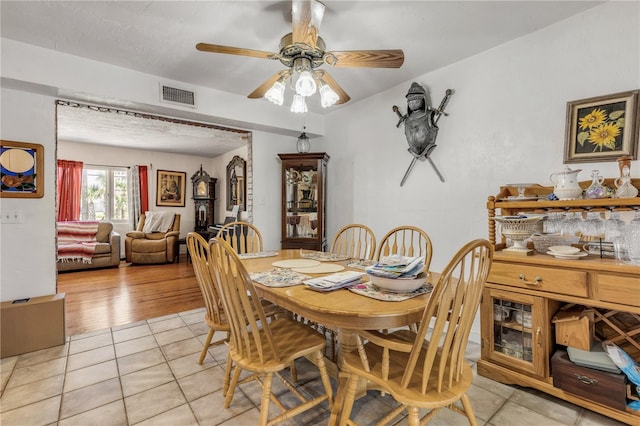 dining space featuring visible vents, ceiling fan, and light tile patterned flooring