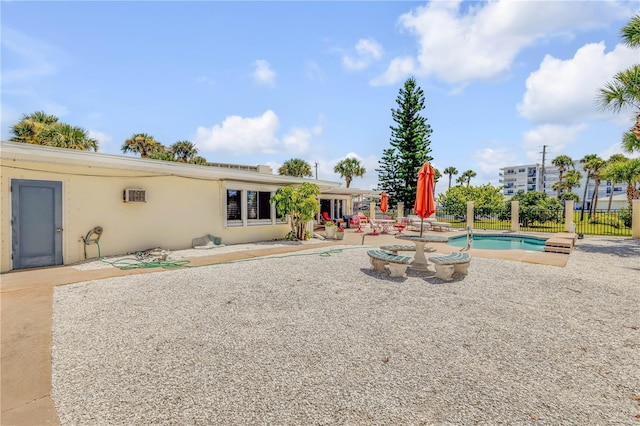 rear view of property with a patio area, fence, and stucco siding