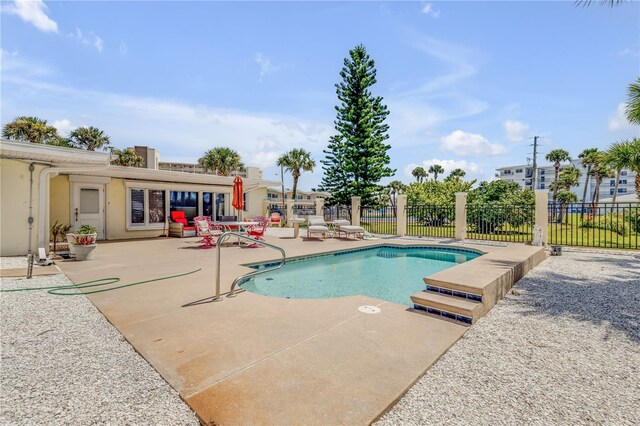 view of swimming pool featuring a patio area, fence, and a fenced in pool