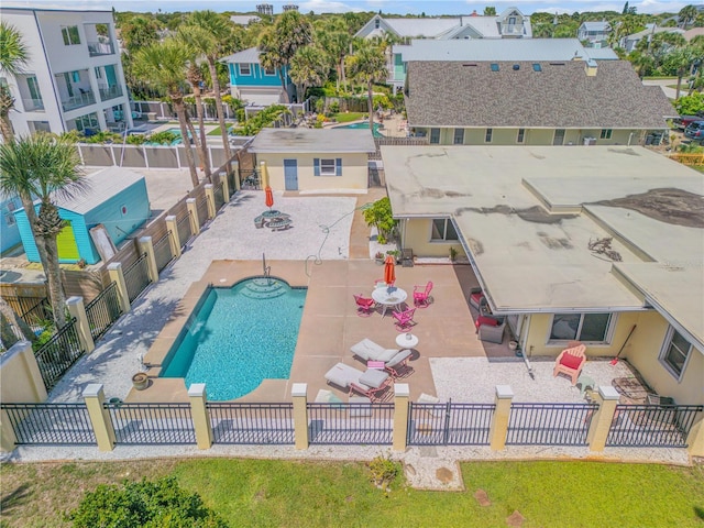 community pool with a fenced backyard, a residential view, and a patio