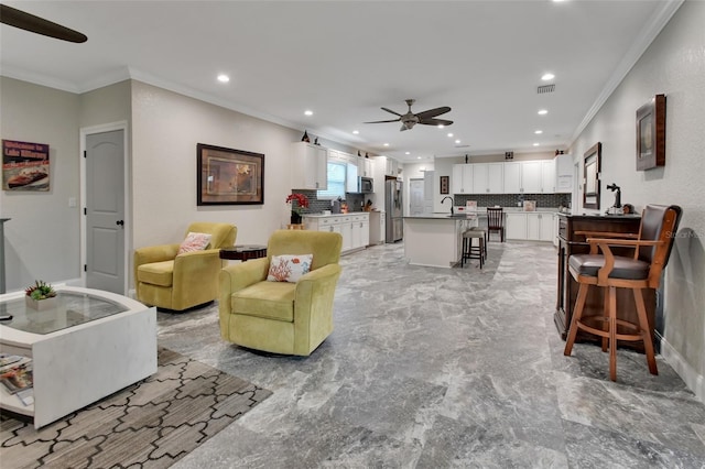 living room featuring ceiling fan, sink, and ornamental molding