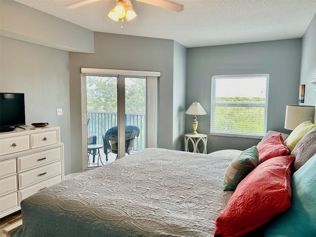 bedroom featuring wood-type flooring, a textured ceiling, access to exterior, and ceiling fan