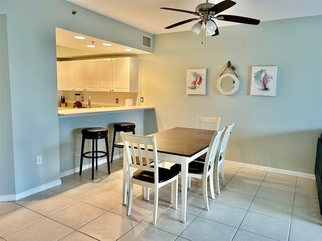 tiled dining space with ceiling fan