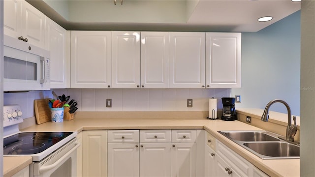 kitchen featuring sink, white cabinetry, decorative backsplash, and white appliances