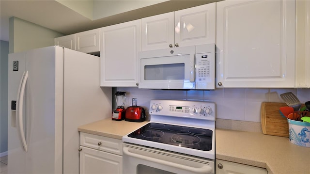 kitchen featuring decorative backsplash, white appliances, and white cabinetry