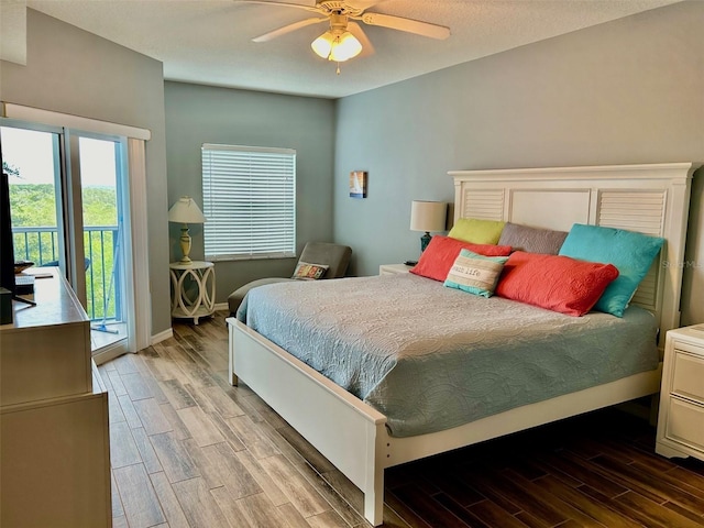 bedroom featuring multiple windows, access to outside, hardwood / wood-style floors, and ceiling fan