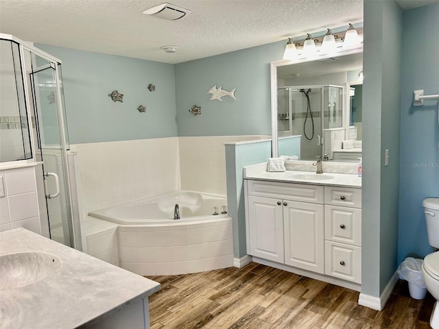 full bathroom with vanity, a textured ceiling, wood-type flooring, and toilet