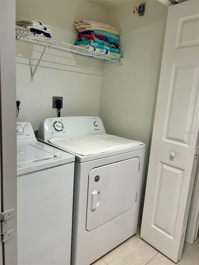 laundry room featuring separate washer and dryer and light tile patterned floors