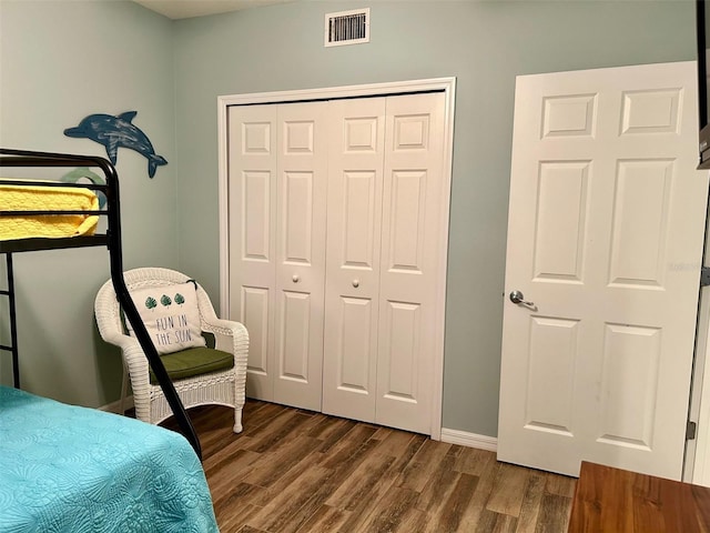 bedroom with dark hardwood / wood-style floors and a closet