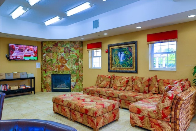 living room with a tiled fireplace and light tile patterned floors