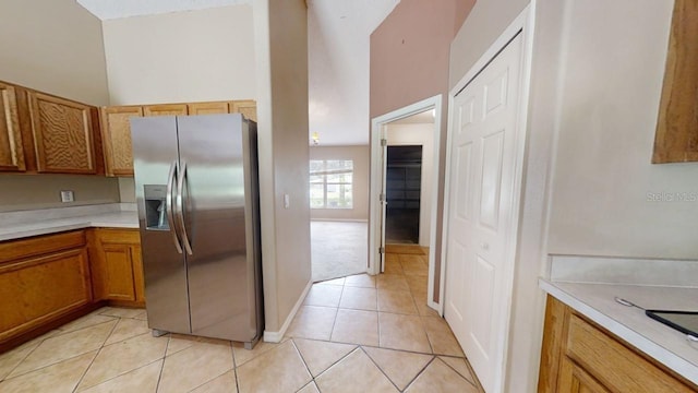 kitchen featuring stainless steel refrigerator with ice dispenser and light tile patterned floors