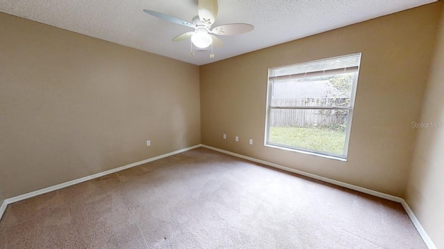 unfurnished room featuring ceiling fan, carpet flooring, and a textured ceiling