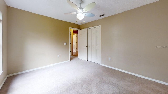 carpeted spare room with ceiling fan