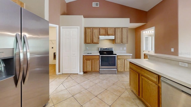 kitchen with light tile patterned floors, stainless steel appliances, and high vaulted ceiling