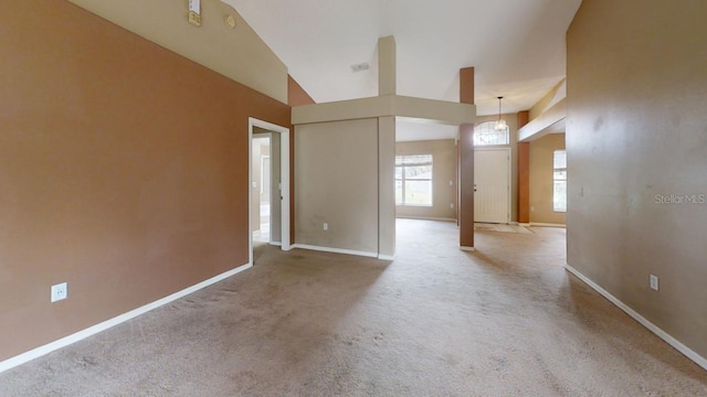 spare room with vaulted ceiling and light colored carpet