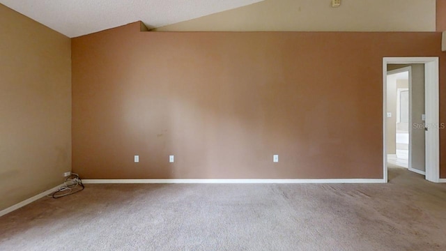 carpeted empty room featuring lofted ceiling